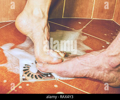 Les amateurs adultes jouant avec les pieds en salle de douche. Beau moment de couple vivant ensemble Banque D'Images