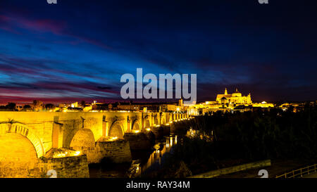 Vue sur la Mezquita, Catedral de Cordoba, à travers le pont romain au coucher du soleil. Une ancienne mosquée mauresque qui est maintenant la cathédrale Mezquita de Cordoue, est un Banque D'Images
