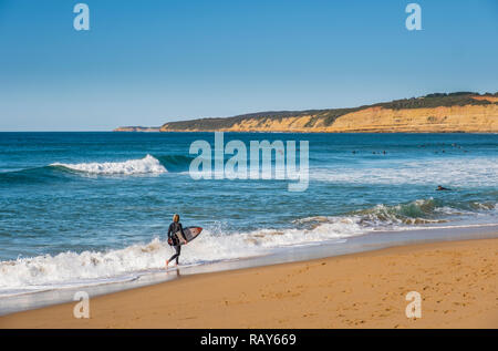 Surfer à Jan Juc beach, Jan Juc, Torquay, Great Ocean Road, Victoria, Australie. Banque D'Images