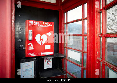 La défibrillation d'urgence défibrillateur externe automatisé (DEA) situé dans une vieille boîte de téléphone rouge dans un village du Lancashire Banque D'Images