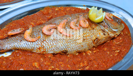 Poisson de style marocain est servi dans le mariage. Poisson avec sauce tomate Banque D'Images