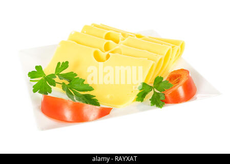 Morceaux de fromage jaune frais avec le persil et les tomates sur une plaque isolé sur un fond blanc en gros plan. Banque D'Images