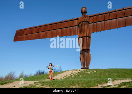 Posant pour des photos par l'Ange du Nord, Gateshead, Tyne et Wear, Angleterre Banque D'Images