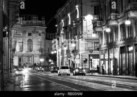 Turin, Piémont, Italie, en vue de la nuit via Cernaia en noir et blanc avec des voitures et des personnes Banque D'Images