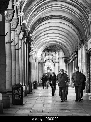 Turin, Piémont, Italie Vue de nuit les gens marcher sous les arcades de la Via Cernaia en noir et blanc Banque D'Images