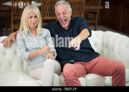 L'homme ayant un bon rire tandis que sa femme pleure Banque D'Images