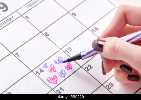 Jeune fille dessin et coloriage coeur forme de calendrier pour la Saint-Valentin avec feutre. L'amour et la Saint-Valentin maison de concept. Close up Banque D'Images