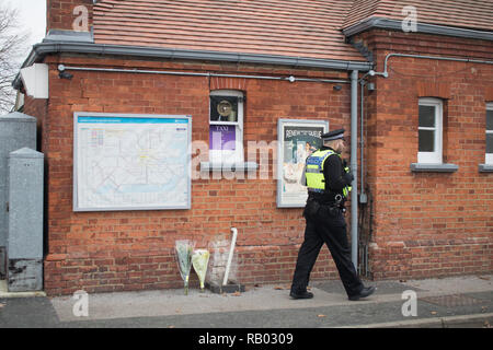 Surrey Horsley, le 5 janvier 2019. Un agent de la police des transports britannique marche dernières tributs floraux laissés à l'extérieur de la gare de Horsley plate-forme dans le Surrey où un homme de 51 ans qui a été désigné comme Lee Pomeroy a été découvert poignardé mortellement sur un train entrant de Guilford à Waterloo, le vendredi : Crédit amer ghazzal/Alamy Live News Banque D'Images