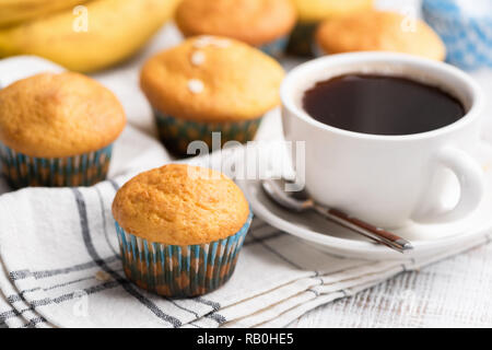 Muffins aux bananes avec des flocons d'avoine et tasse de café sur le tableau blanc, vue rapprochée Banque D'Images