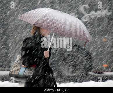 Belgrade, Serbie - 15 décembre 2016 : Une jeune femme élégante de marcher seul sous parapluie dans les fortes chutes de neige dans la rue Ville Banque D'Images