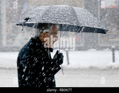 Belgrade, Serbie - 15 décembre 2018 : un homme âgé marcher seul sous égide snowy city street à de fortes chutes de neige Banque D'Images