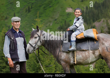 Homme Kazakh avec son petit-fils sur le cheval, le Kazakhstan. Banque D'Images