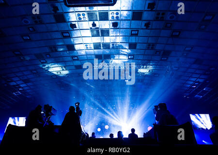 Un groupe de travail de cameramen pendant le concert. Nombre d'événement. Silhouettes d'ouvriers contre l'arrière-plan de faisceaux colorés. Banque D'Images