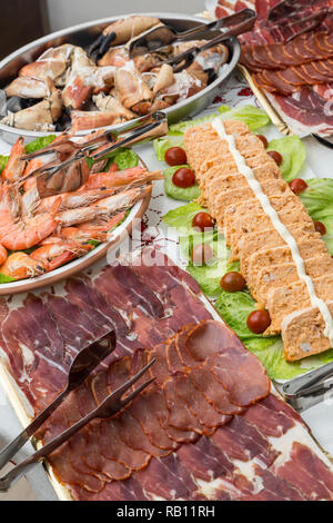 Bacs avec saucisses ibériques, crevettes, fruits de mer, poissons, gâteaux de Noël table buffet Banque D'Images