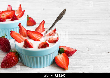 Yogourt aux fraises en bonne santé avec les baies fraîches et déposer sur la table en bois blanc. petit-déjeuner sain. close up with copy space Banque D'Images