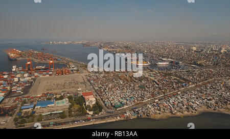 Vue aérienne du port du fret industriel avec des navires et des grues. Vue sur le port du fret et de terminal à conteneurs. Grues à conteneurs dans la baie de Manille. Cargo ship in port industriel. Manille, Philippines. Banque D'Images