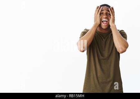 Guy se sentir triste en criant à haute voix presser avec les mains sur la tête de faire face à l'expression de sentiment assez misérable, en détresse et troublé, la perte de contrôle sur les émotions après rupture déchirante Banque D'Images