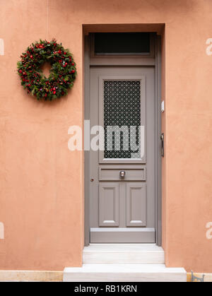 Couronne de Noël Décoration. Porte d'entrée en bois, la façade de l'immeuble résidentiel dans la vieille ville de Plaka, Athènes Grèce. Banque D'Images