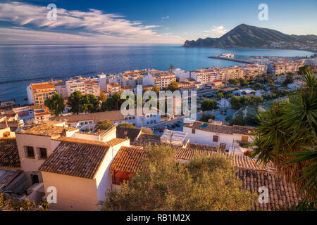 Un panorama d'une Altea et la mer Méditerranée juste avant le coucher du soleil avec une vue sur la montagne et le ciel bleu et nuages dans la distance Banque D'Images