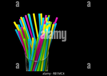 Différentes couleurs de pailles en plastique placé dans un fond noir verre Banque D'Images