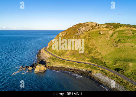 L'Irlande du Nord, Royaume-Uni. Causeway Coastal Route a.k.a Côte d'Antrim Road près de Ballygalley Tête et resort. L'une des plus belles routes côtières d'Europe. Banque D'Images