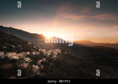 Soleil derrière les montagnes sur le village de Belgodere en Balagne Corse Banque D'Images