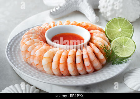 Gros plan sur couronne de crevettes avec sweet chili sause avec l'aneth et des tranches de citron vert Banque D'Images