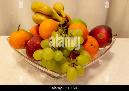 Bol en verre debout sur une table remplie de fruits différents, photo du nord de la Suède. Banque D'Images