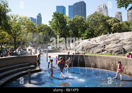 Les enfants jouissent de la protection sprinkleur dans Heckscher Jeux, Central Park, NYC Banque D'Images