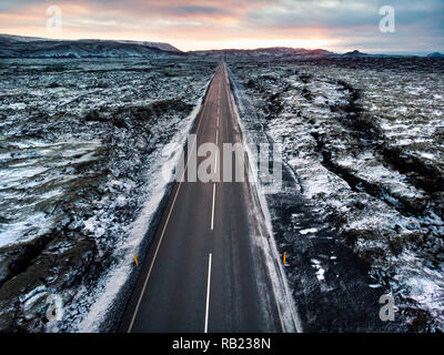 Route en Islande entouré par des champs de lave recouverts de neige vue aérienne Banque D'Images