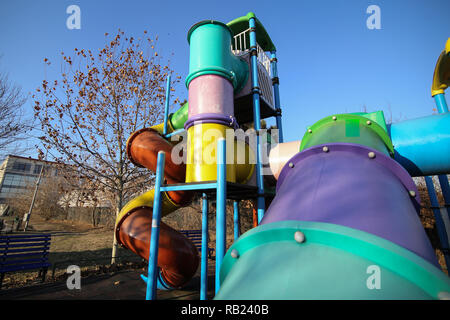 Aire de jeux pour enfants colorés dans un parc en hiver, avec des toboggans en plastique et autres articles Banque D'Images