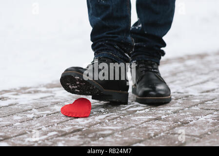 Foule aux pieds l'amour. Symbole de la séparation. Un homme a marché sur une chaussure coeur décoratif Banque D'Images