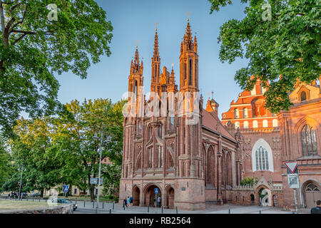 Vilnius, Lituanie - 20 juin 2018 - L'église Sainte-Anne avec certains touristes autour d'elle dans un coucher du soleil la lumière en Lituanie Banque D'Images