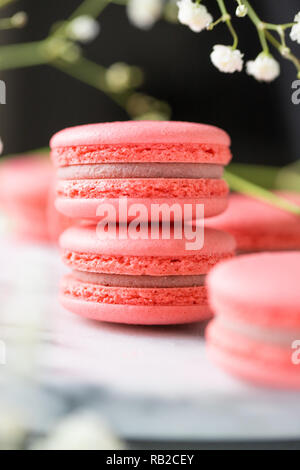 Pile de rose macaron gâteaux français sur un marbre blanc. Printemps nature morte. Banque D'Images