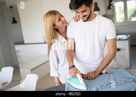 Girl peine petit ami pendant le repassage shirt Banque D'Images