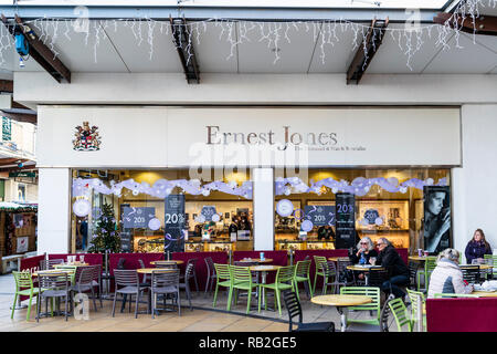 L'extérieur et en face d'Ernest Jones watch shop peu de gens le café en terrasse extérieure. L'hiver. Vente panneaux dans la fenêtre de magasin avec 20 % de rabais. Banque D'Images