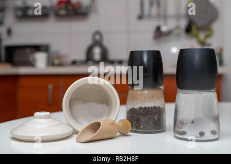 Les épices dans des conteneurs sur la table de la cuisine. Équipement dans la cuisine. Fond clair. Banque D'Images