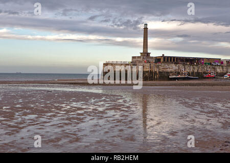 Reflet de la jetée dans le bras de Port sable humide à marée basse avec un ciel crémeux Banque D'Images