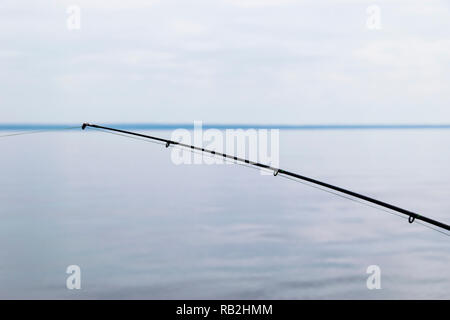 Canne à pêche en bateau avec la ligne sur un beau paysage nuageux Banque D'Images
