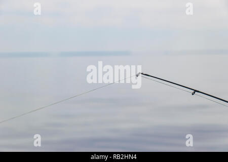 Canne à pêche en bateau avec la ligne sur un beau paysage nuageux Banque D'Images
