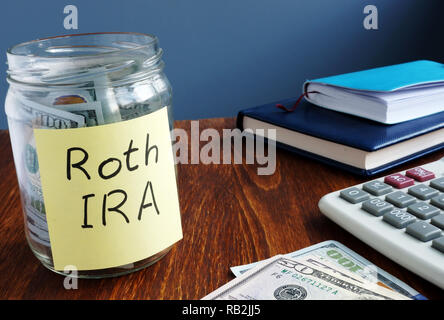 Roth ira inscrites sur une étiquette de la fiole avec de l'argent. Banque D'Images