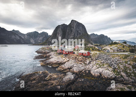 Panorama de la célèbre attraction touristique Hamnoy village de pêcheurs sur les îles Lofoten, Norvège avec près de Reine rorbu rouge maisons dans l'automne avec les nuages et ciel bleu et les vagues de l'océan. Banque D'Images