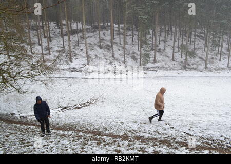 Les jeunes hommes en marche à travers la neige Parc Squerryes entre Westerham, Hosey et commun dans Chartwell Kent. Mars 2018 Banque D'Images