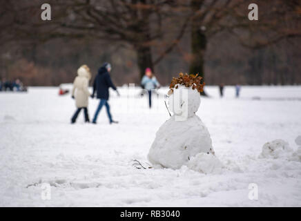 Munich, Allemagne. 06 Jan, 2019. Les gens marchent derrière un bonhomme de neige dans le jardin anglais. Photo : Lino Mirgeler/dpa dpa : Crédit photo alliance/Alamy Live News Banque D'Images