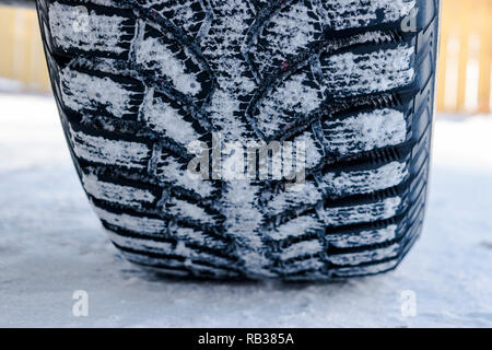 Le pneu de voiture dans la neige de près. Location de pistes sur la neige. Des traces de la voiture dans la neige. Pneus d'hiver. Pneus couverts avec de la neige en hiver road Banque D'Images