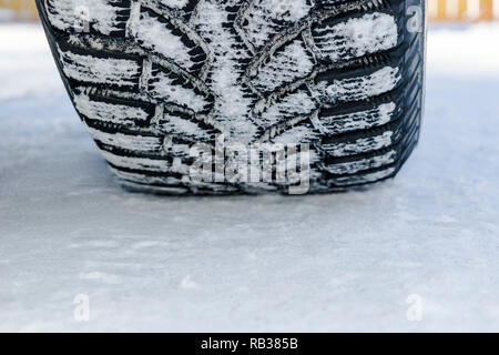 Le pneu de voiture dans la neige de près. Location de pistes sur la neige. Des traces de la voiture dans la neige. Pneus d'hiver. Pneus couverts avec de la neige en hiver road Banque D'Images