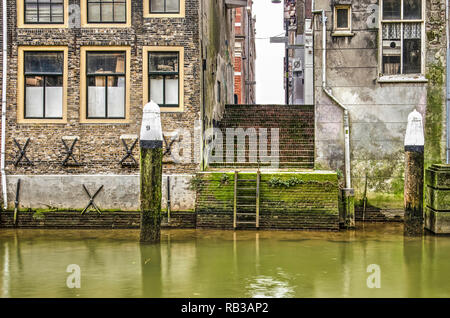 Dordrecht, Pays-Bas, le 6 janvier 2019 : escalier entre deux vieilles maisons en briques dans le centre historique de la ville, menant jusqu'à l'eau d'Voorstra Banque D'Images