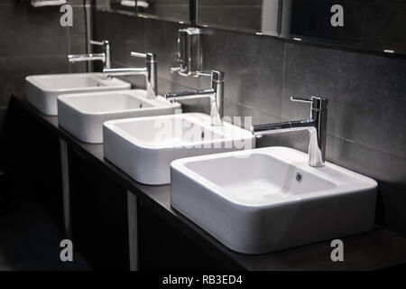 Les puits moderne avec miroir dans les toilettes publiques Banque D'Images