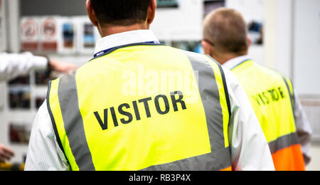Les visiteurs portant des EPI dans une usine de fabrication Banque D'Images
