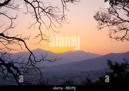 Vue d'un coucher du soleil dans un cadre d'arbres pour signifier un concept de tourisme Banque D'Images